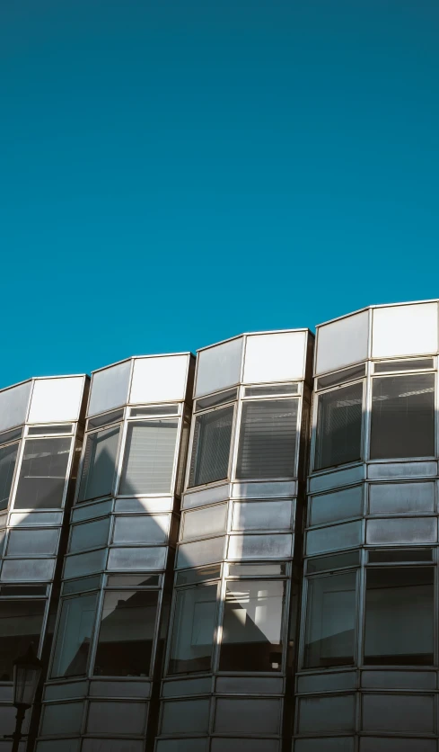 a row of windows in front of a building with a clock on the side