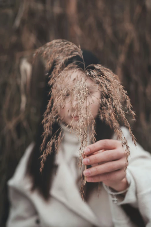 the woman is hiding in the dried plant