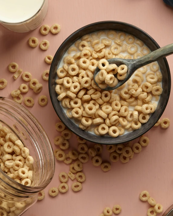 bowl of cereal on table next to jars and containers