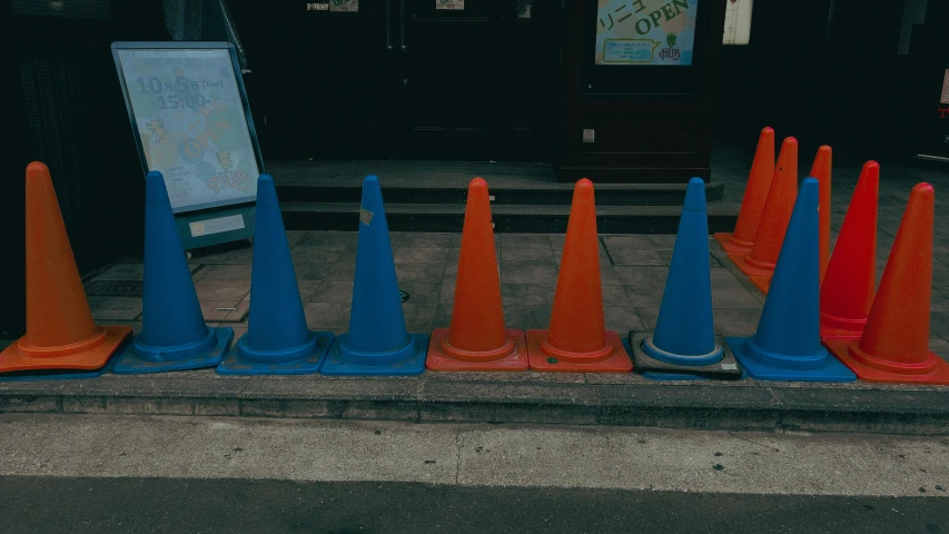 a row of traffic cones that are sitting on a sidewalk