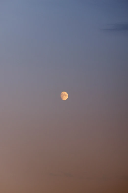 an airplane flying over a mountain range under a full moon