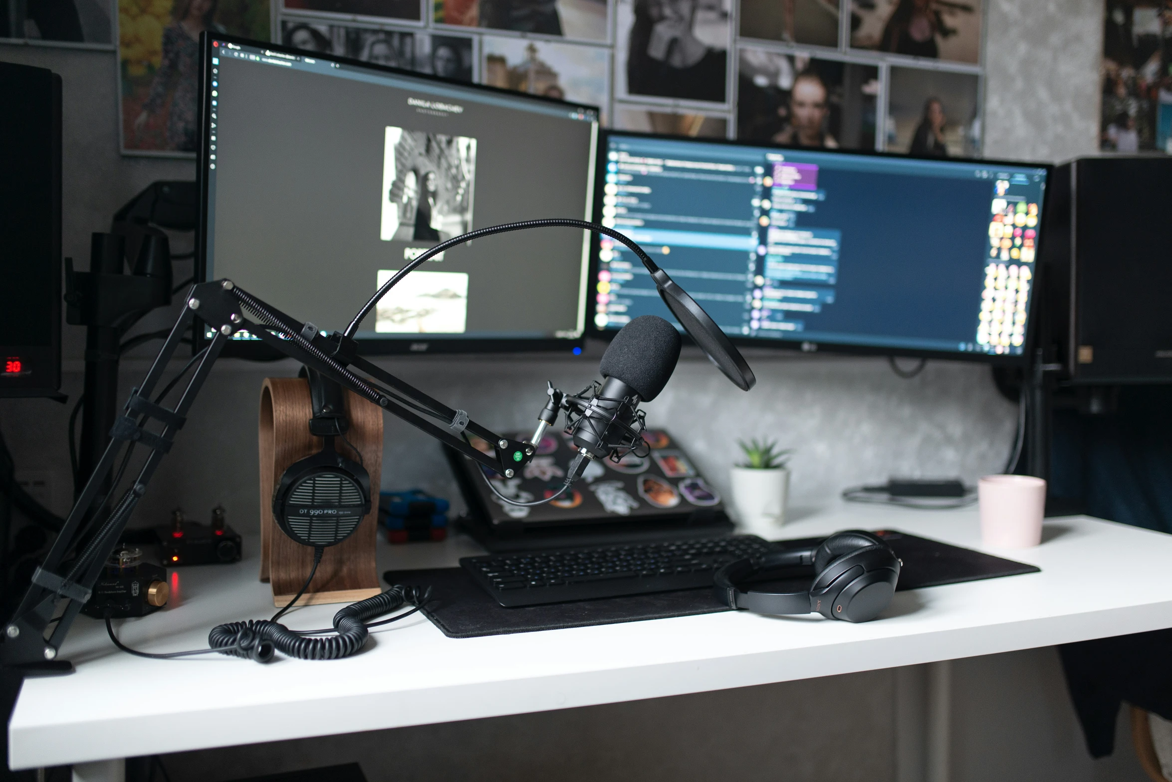a white desk with two computer monitors and a microphone on it