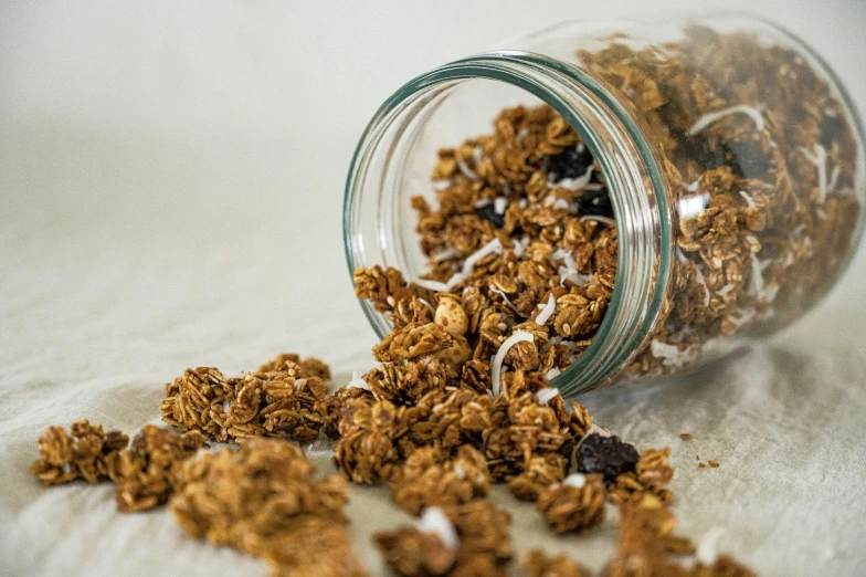 granola spilled out of the jar onto a floor