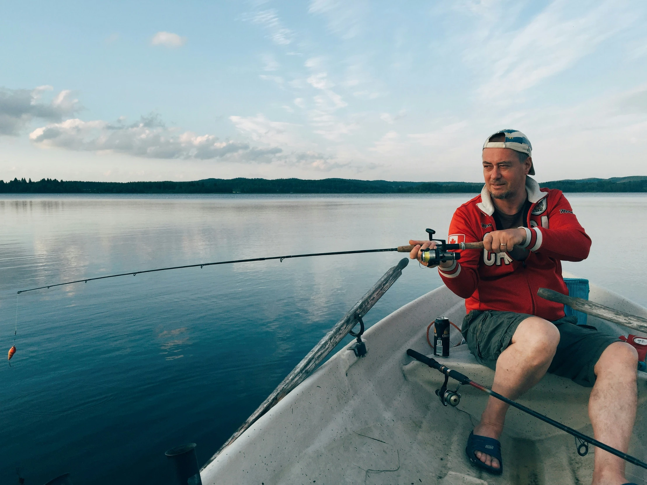 a man sitting in a boat fishing on the water