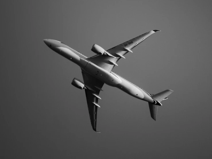 a large white jetliner flying through a gray sky