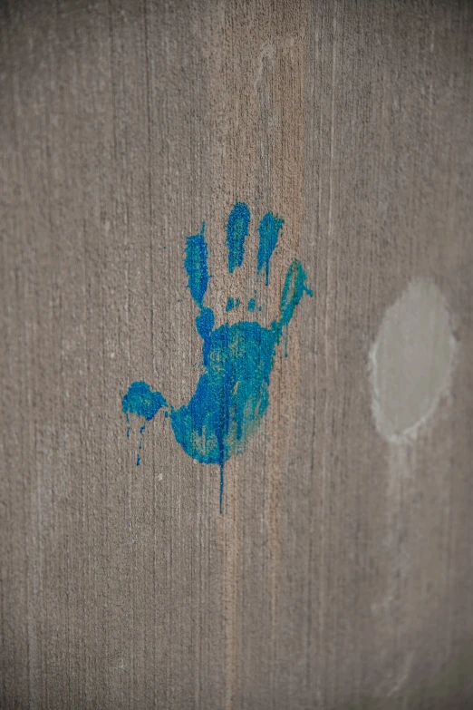 blue spray painted on a wall showing a painted hand