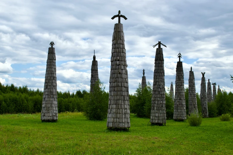 these trees are made out of logs on the grass