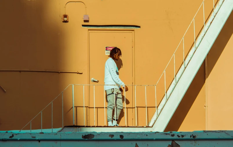 a woman standing in the sun near stairs