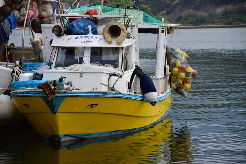 a yellow boat sitting in a harbor with other boats