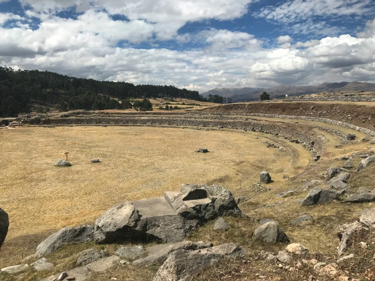 the landscape of an ancient roman city has stones and grass