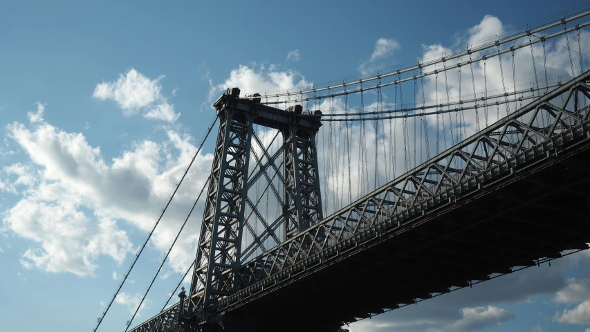 a bridge going across over the water with a blue sky above