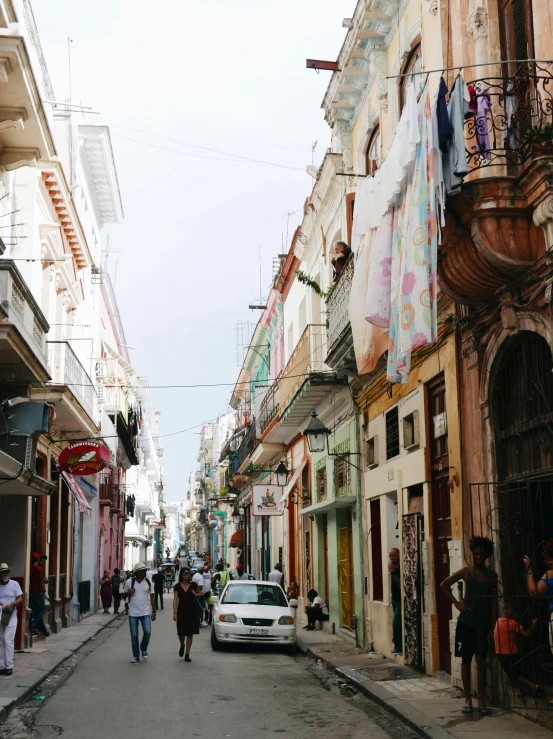 some people are walking along the street and cars