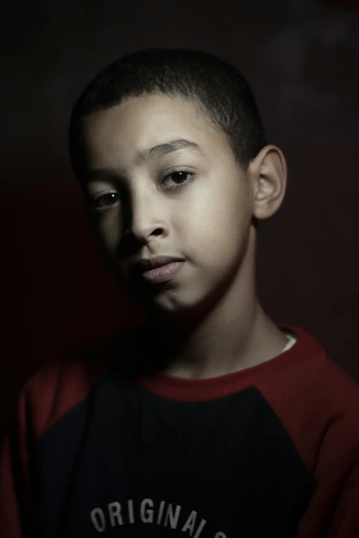 a boy with dark hair and dark eyes staring into the camera