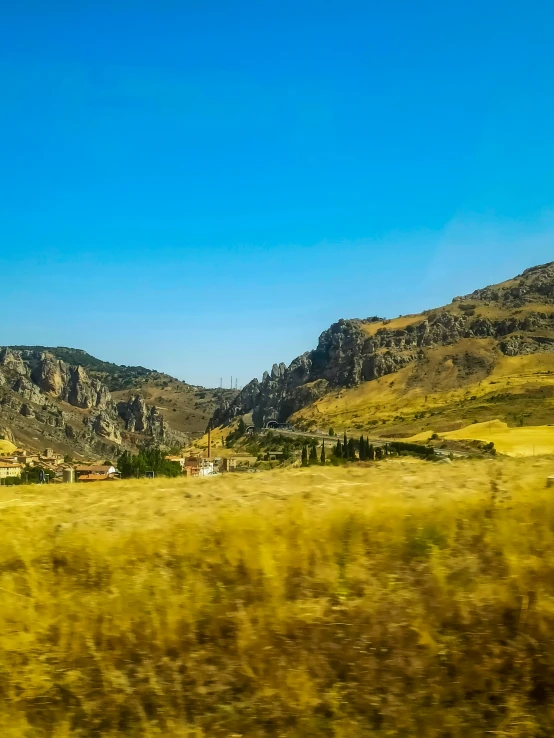 an image of a view from the bus window looking out of the train window at the mountains