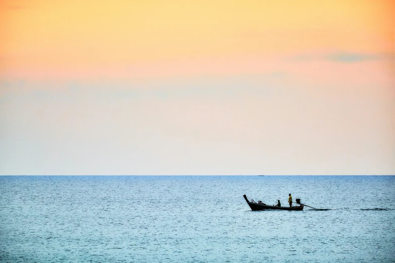 two people in a small fishing boat at the end of an ocean