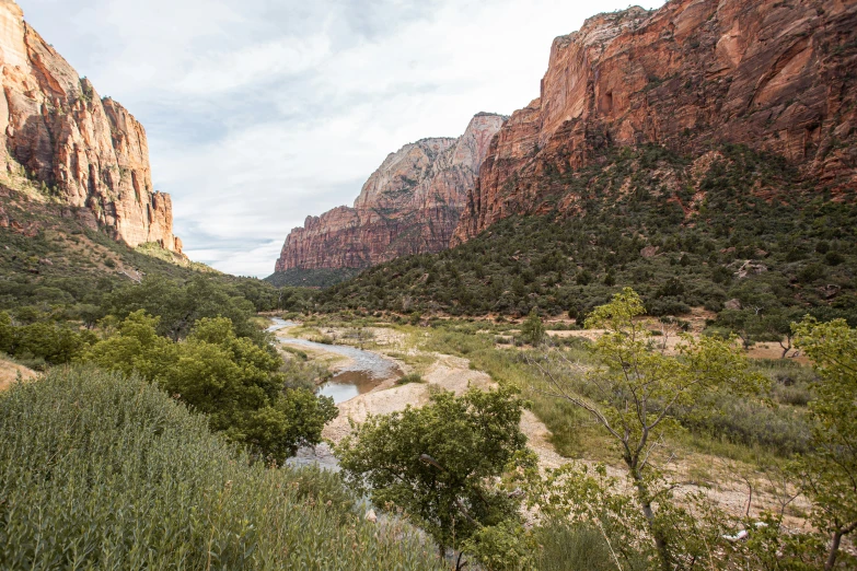 an empty river is nestled between some rocky peaks