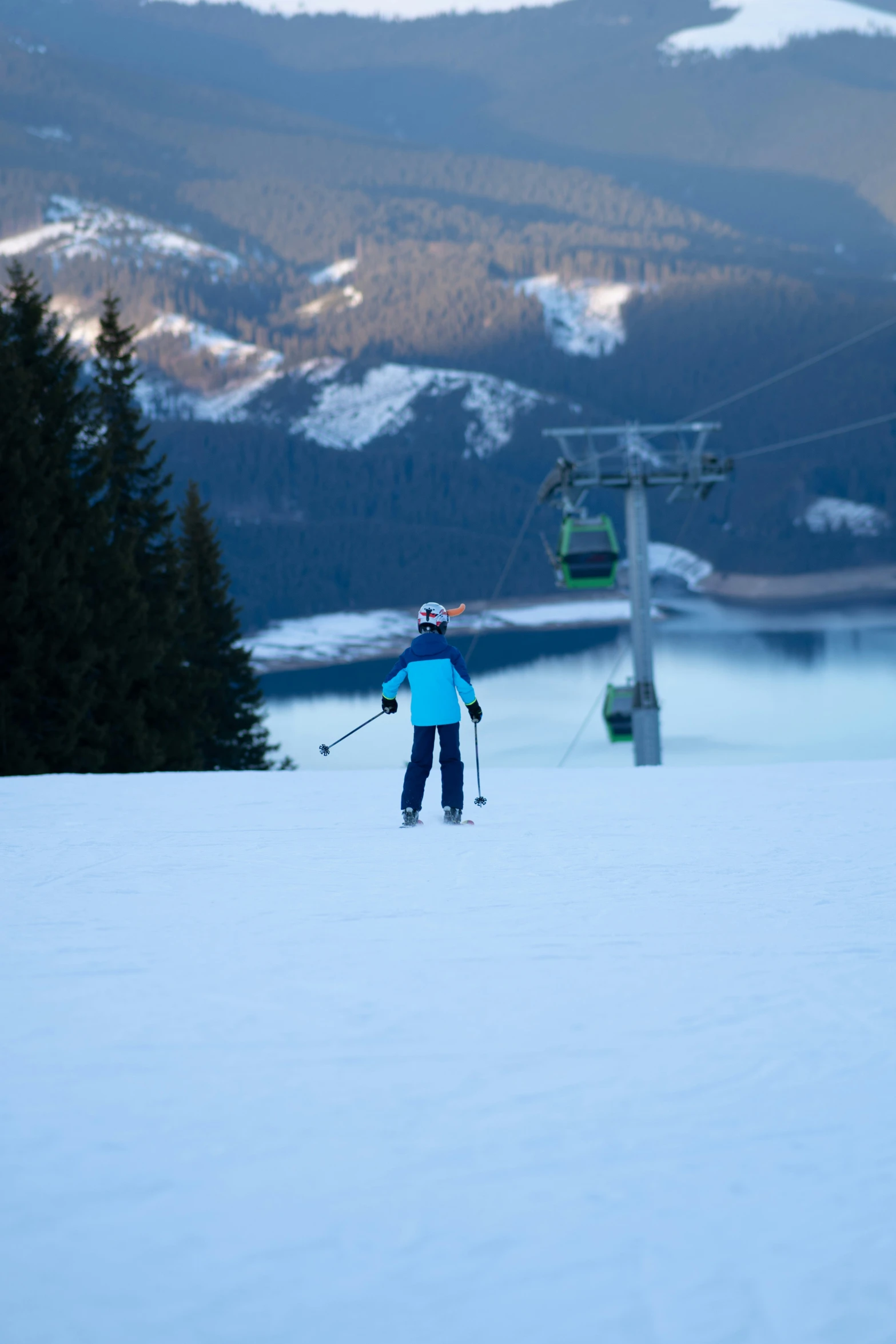 someone skiing down the slope with trees in background