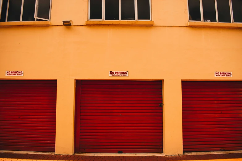 two red doors are on a yellow building