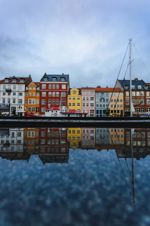 colorful buildings are reflected in the water of a marina