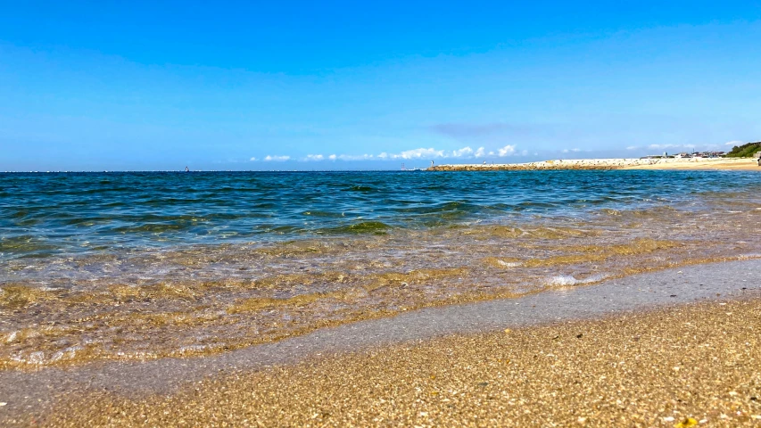 a rocky beach near the ocean under a blue sky