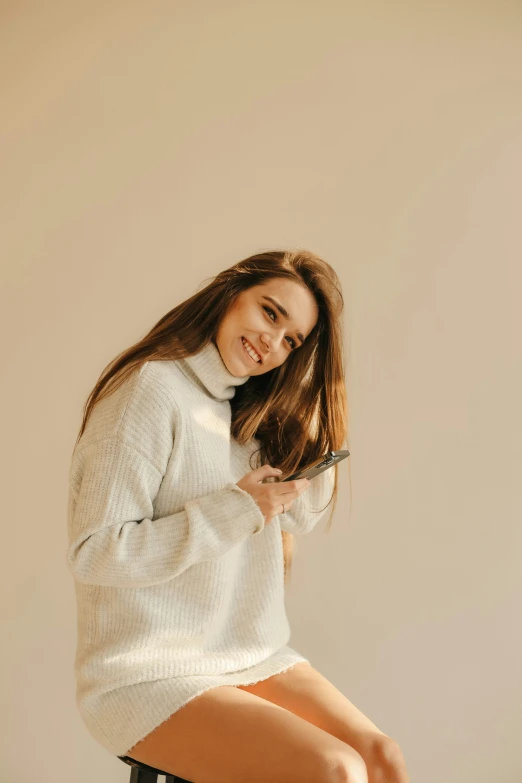 woman sitting on a stool with one foot and smiling