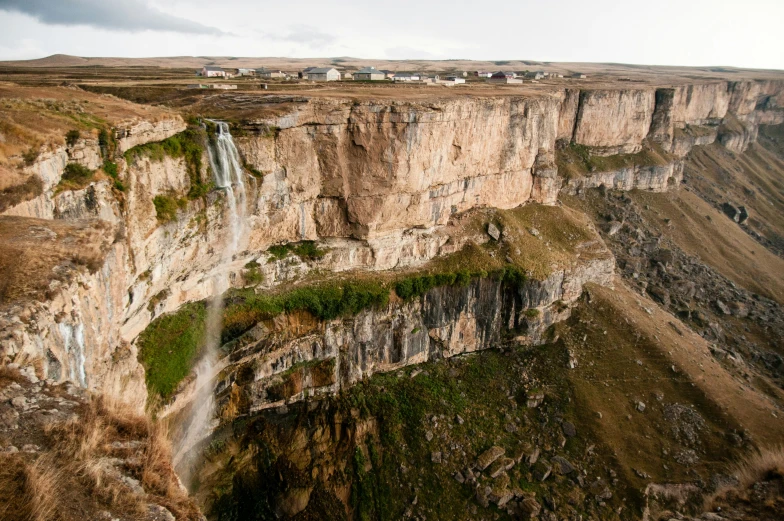 an airplane flying over a large and rocky cliff