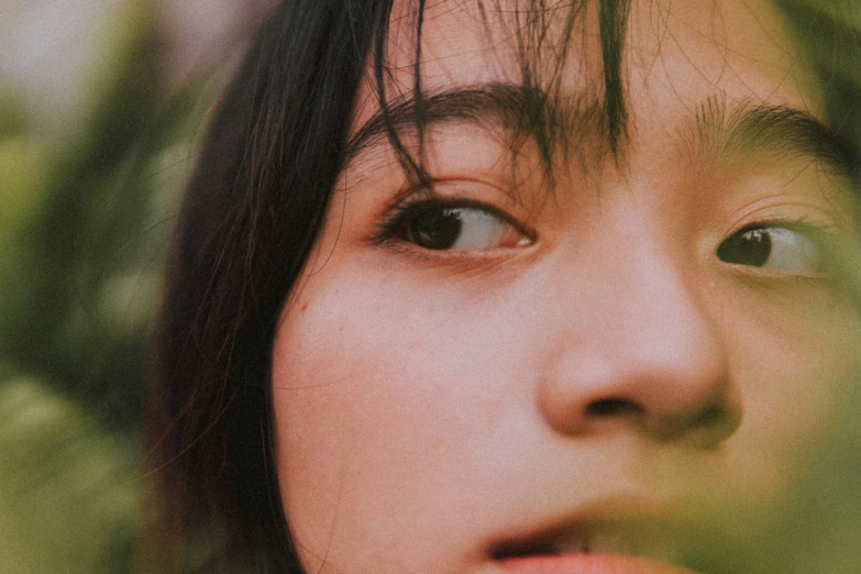 an asian woman with her eyes close together