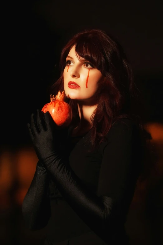 a woman holding an apple and looking off into the distance