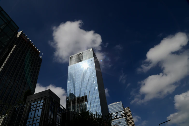 a po of clouds in the sky between a large building