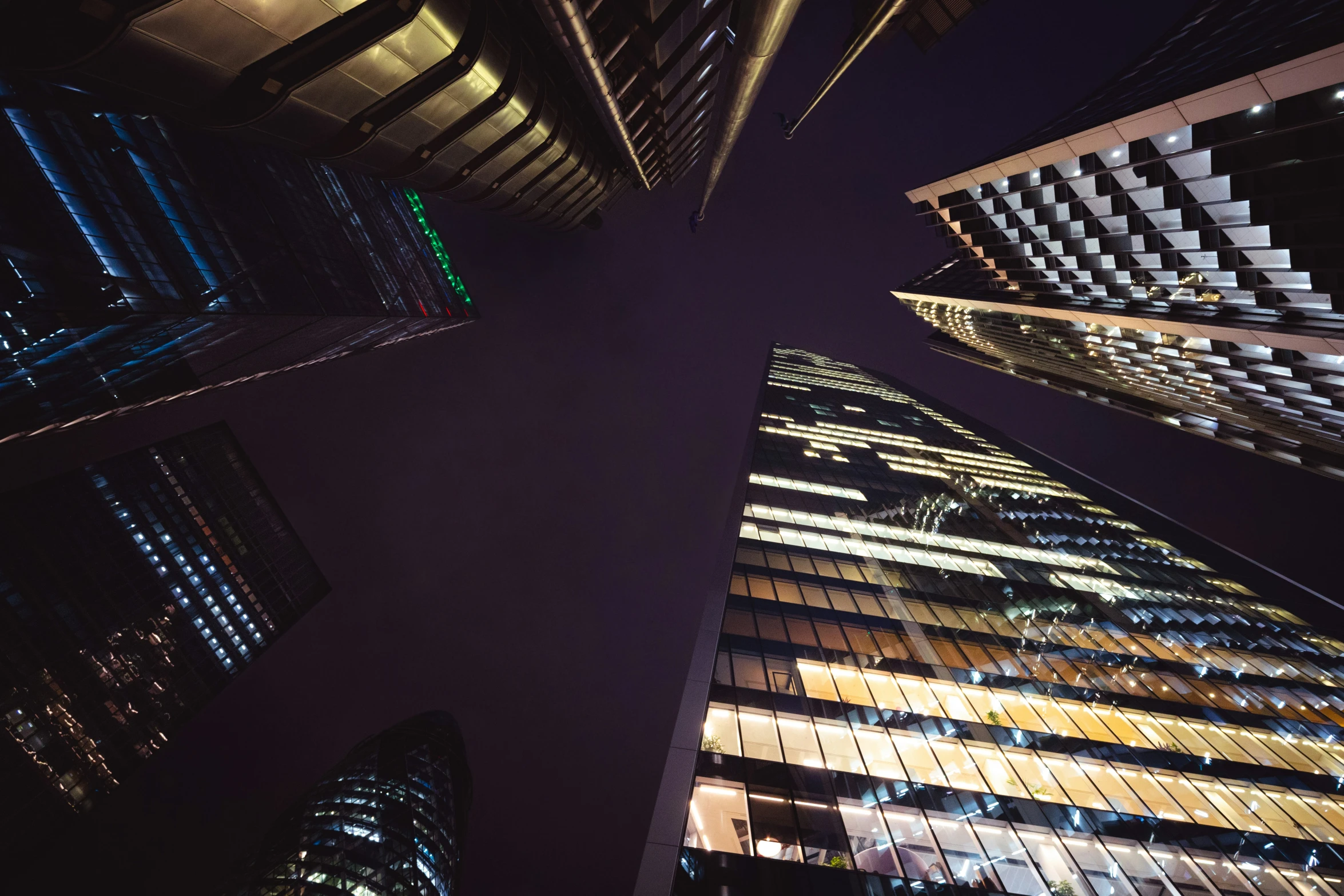 view looking up at tall skyscrs in the night