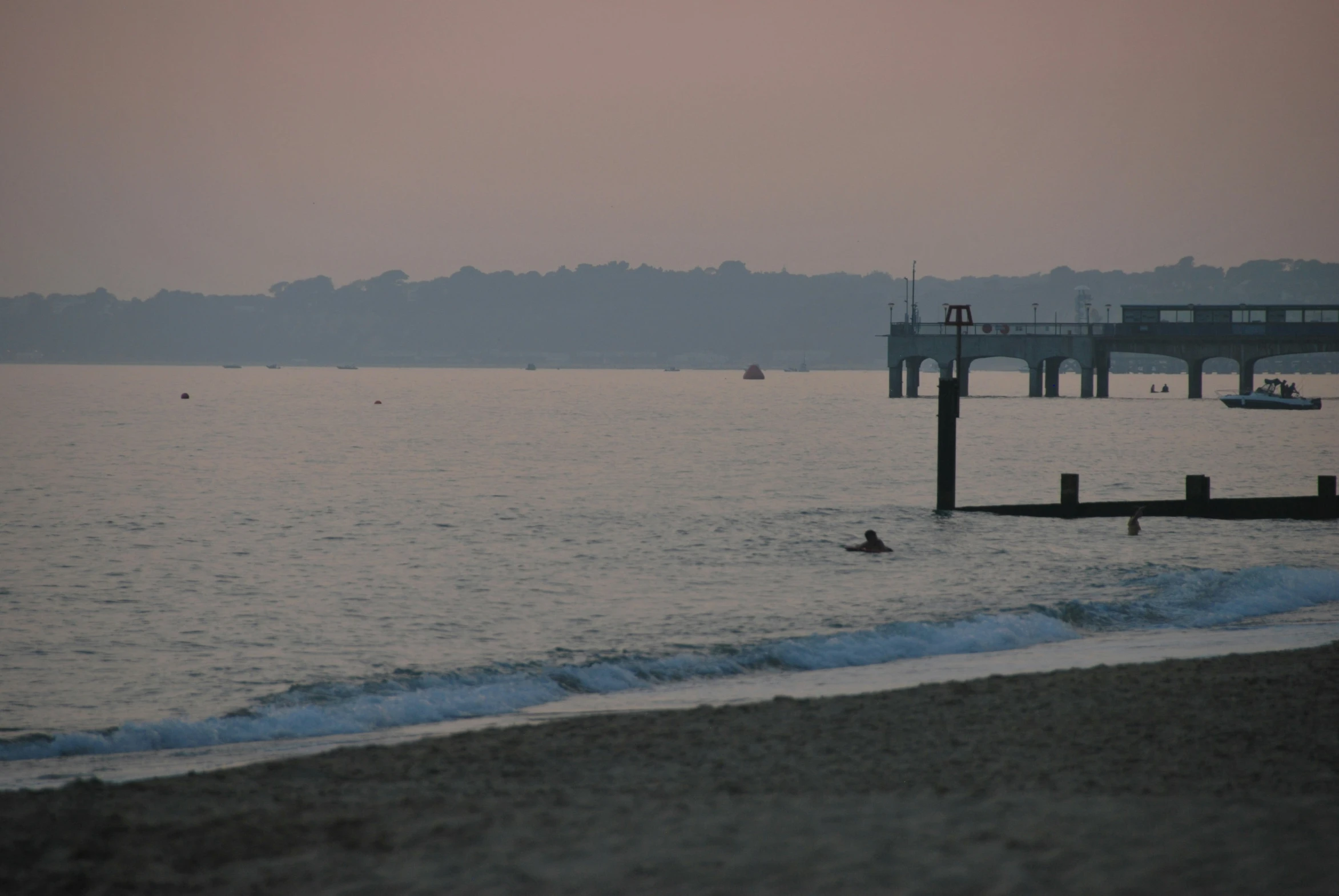 an empty beach next to a dock on a cloudy day