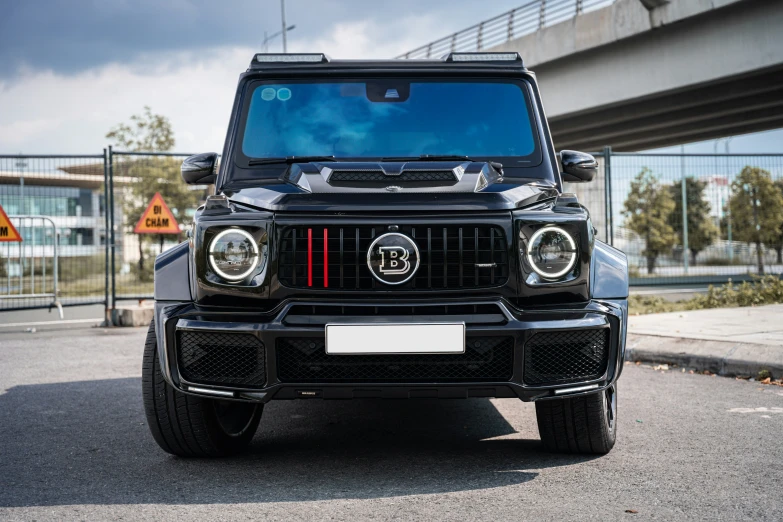 the front of a black and grey suv with the lights on