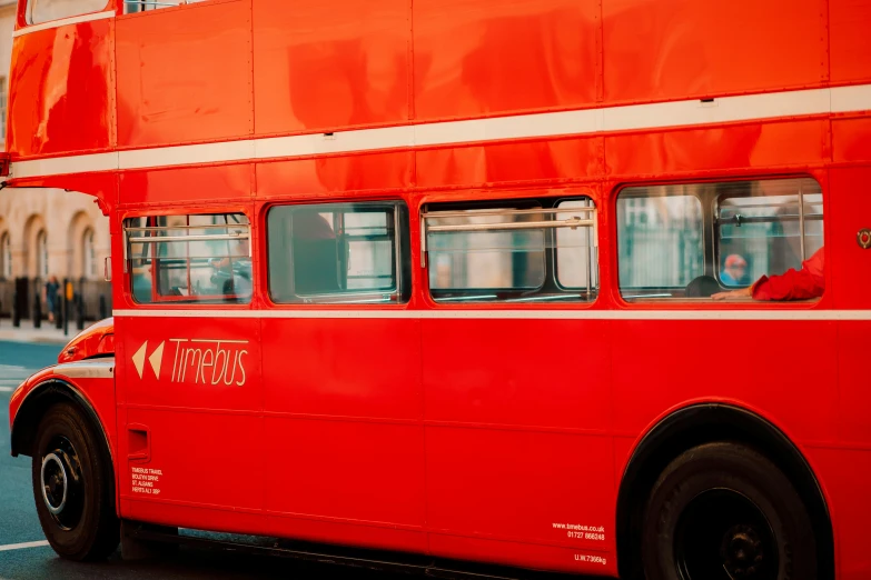 a red double decker bus is parked in a parking lot