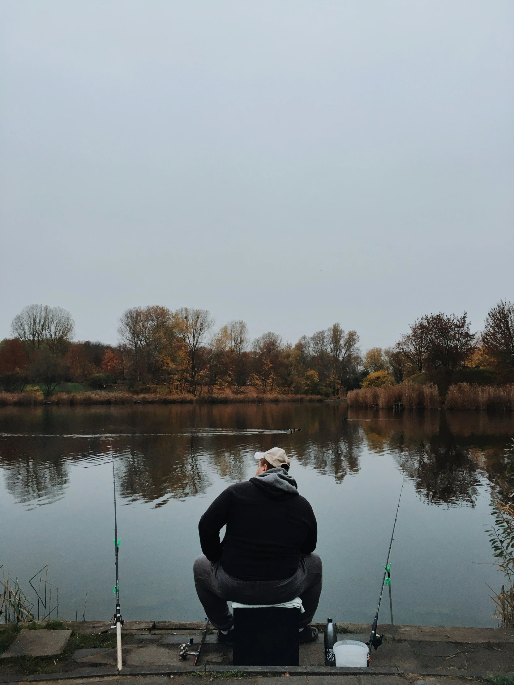 a man is sitting in a dock with fishing rods