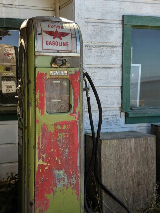 an old gas pump outside a house with its door open