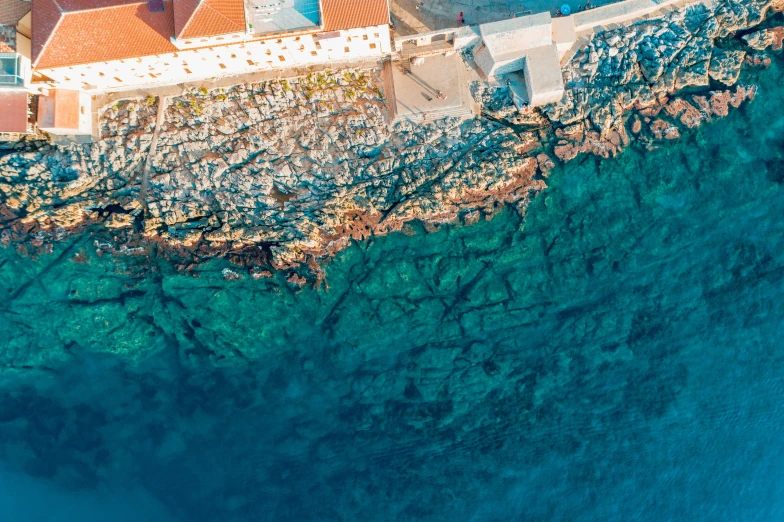 an aerial view of a beach with buildings and blue water