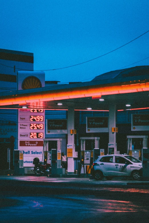 a gas station at night with lit signs