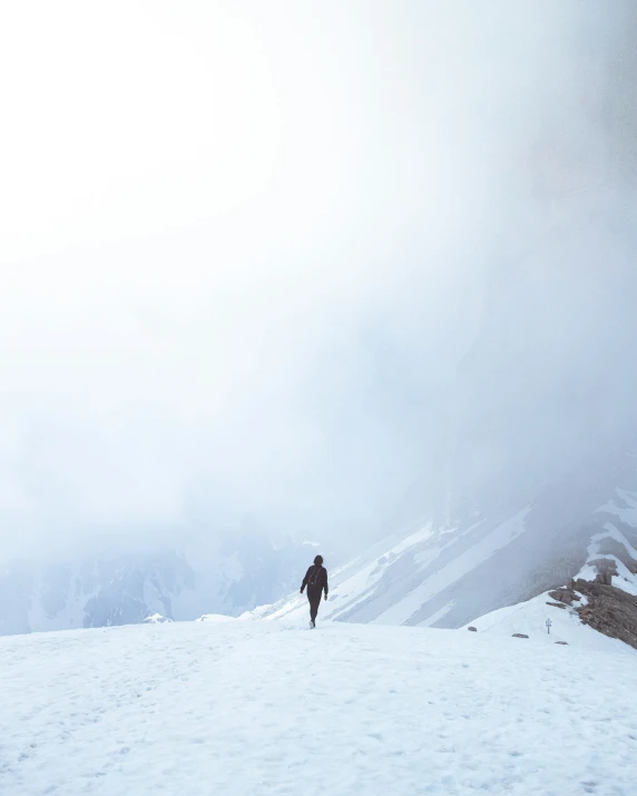 the lone person hikes up a snowy mountain