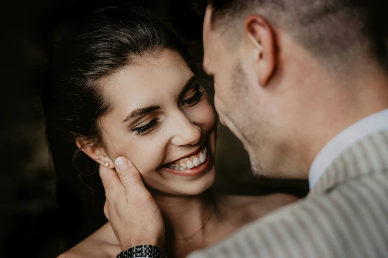 a man and woman standing next to each other and smiling