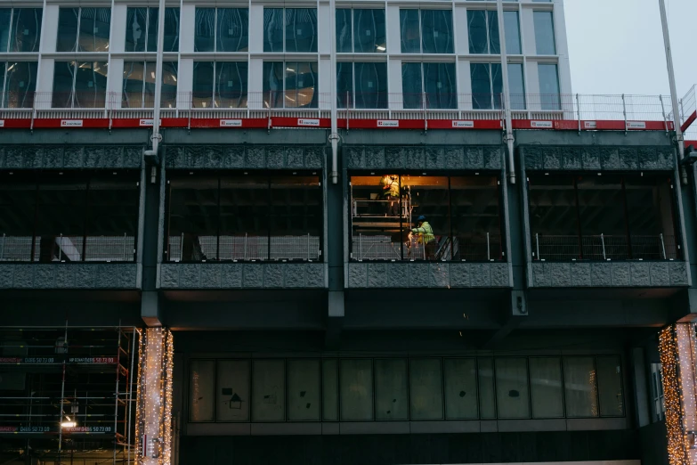 a man on a bicycle under a very tall building