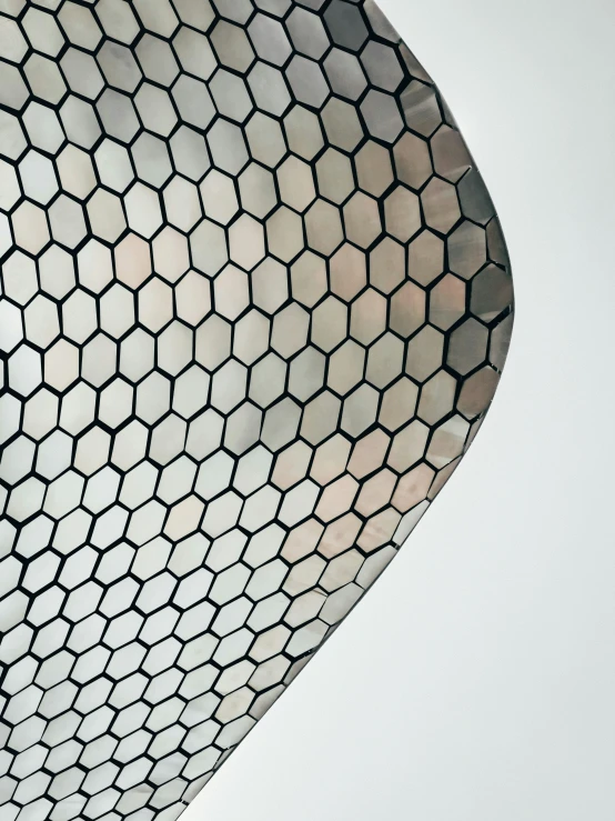 a large circular metal object with hexagonal pattern on it