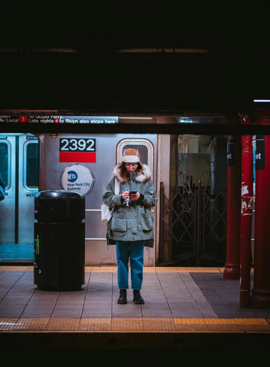 a person standing on a subway platform waiting for train