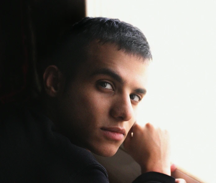 a young man looks away from the camera