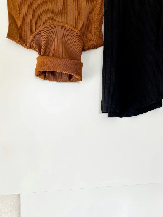 two pairs of clothes hang up on a wall