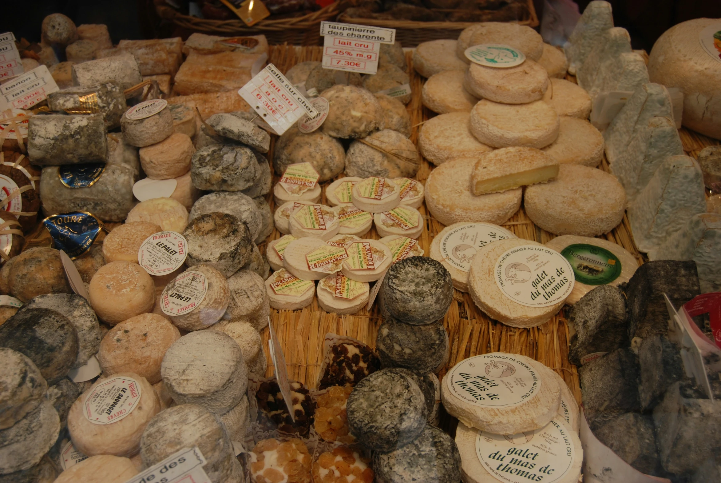 the shelves are filled with cheeses on display