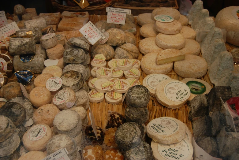 the shelves are filled with cheeses on display