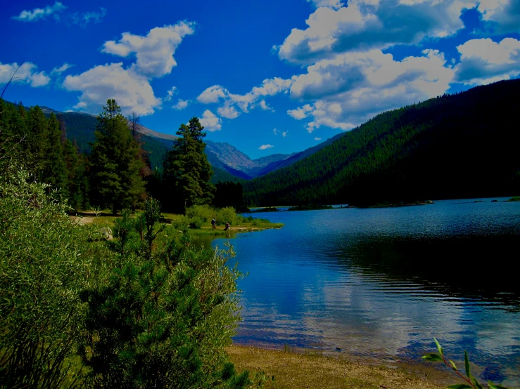 beautiful landscape of blue water, green grass and mountains