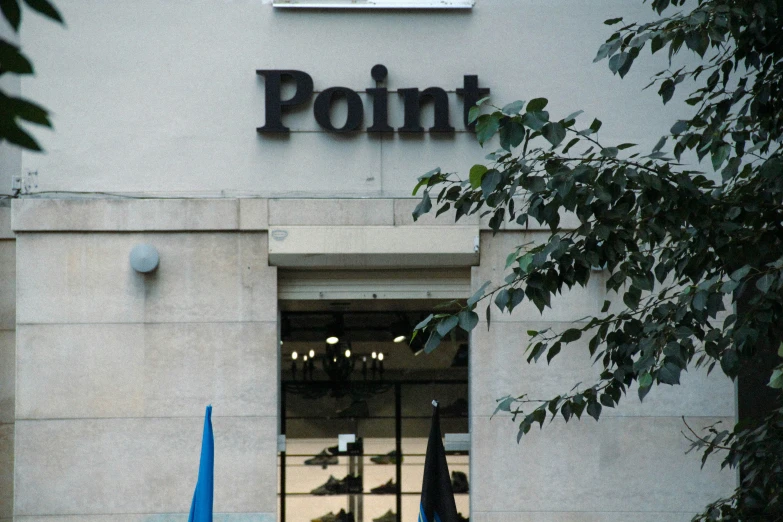 large building that has an entrance with a point sign in the front