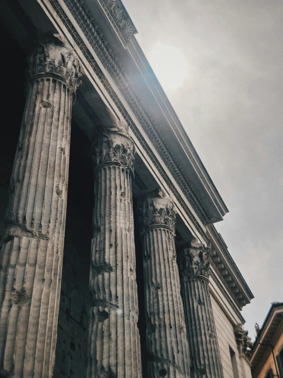 two large columns against the sky behind a building