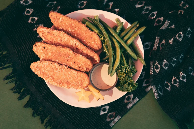 an arrangement of fish, broccoli, and other food items on a plate